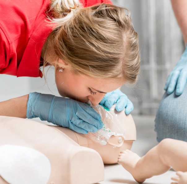 adult woman doing cpr on dummy
